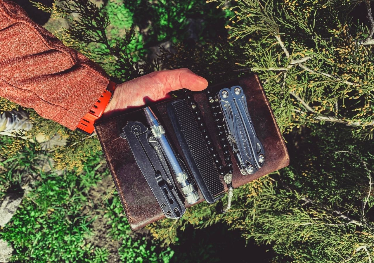 Mężczyzna trzymający w ręku skórzane etui z multitoolem