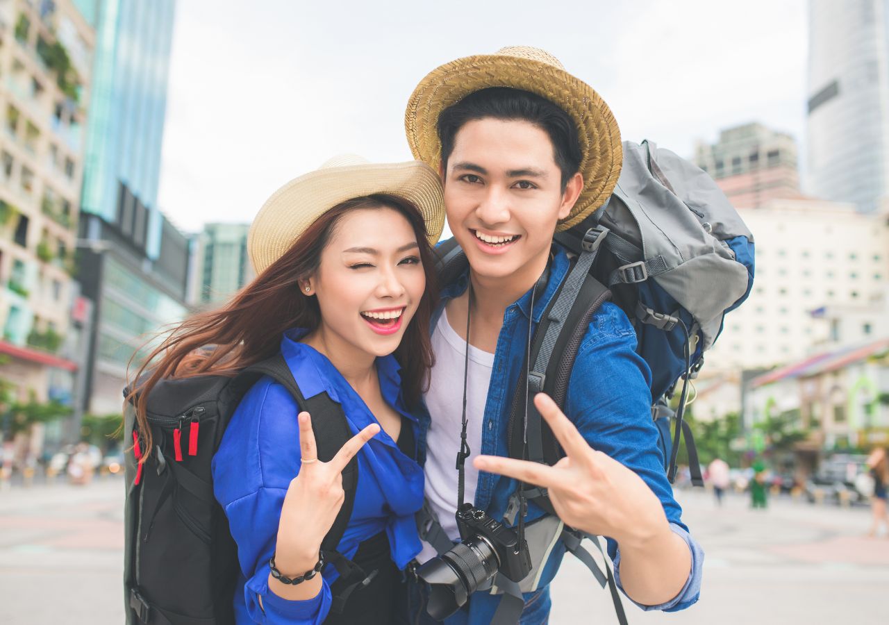 Para turystów pokazuje znak zwycięstwa będąc radośnie na wakacjach