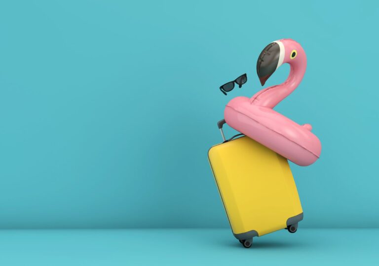 Różowy dmuchany flaming na żółtej walizce