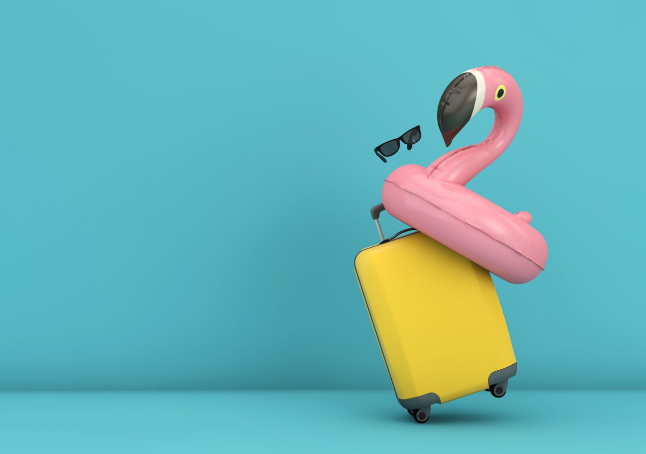 Różowy dmuchany flaming na żółtej walizce