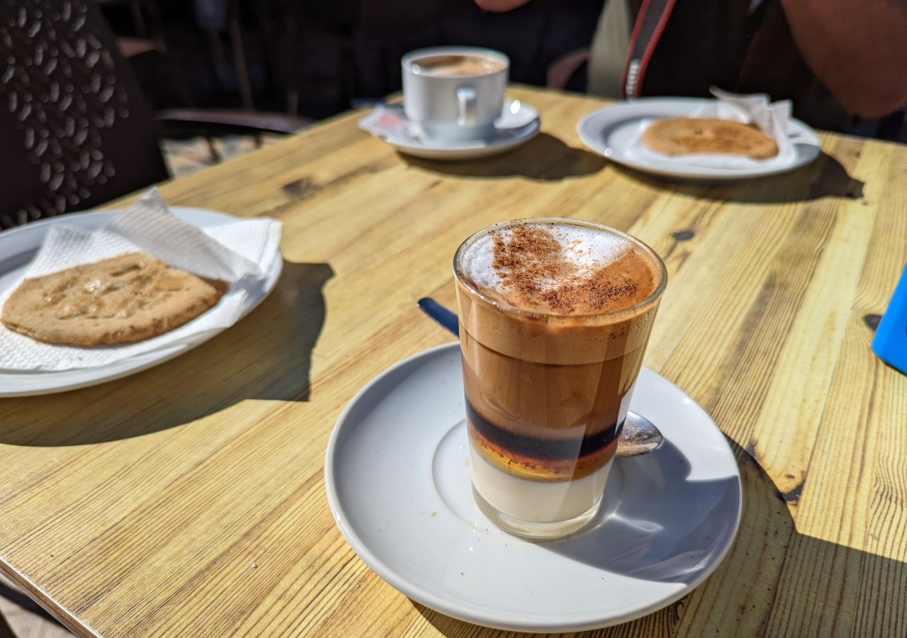 Szklaneczka z barraquito na stole wśród innych łakoci