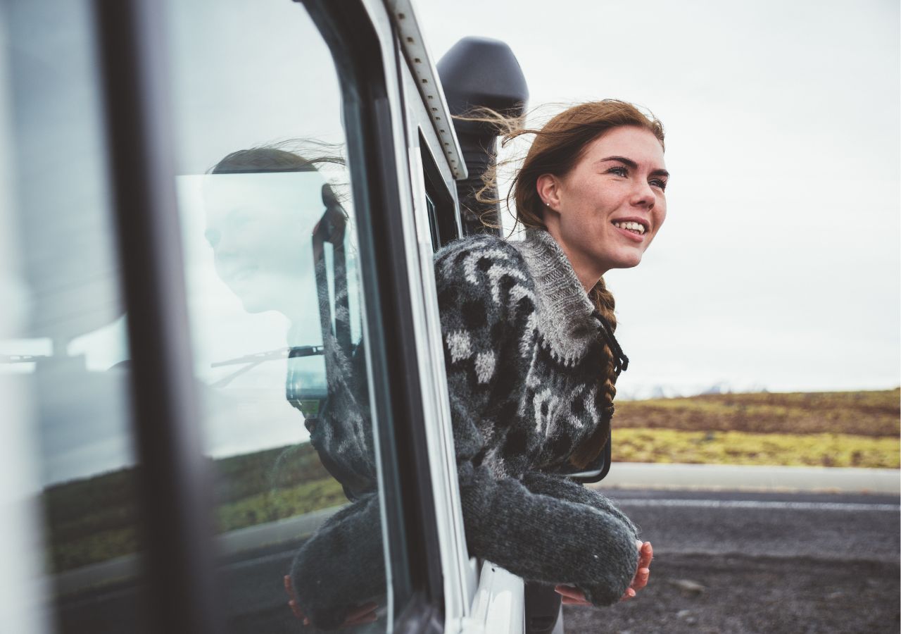 Turystka wygląda z okna samochodu w czasie jazdy