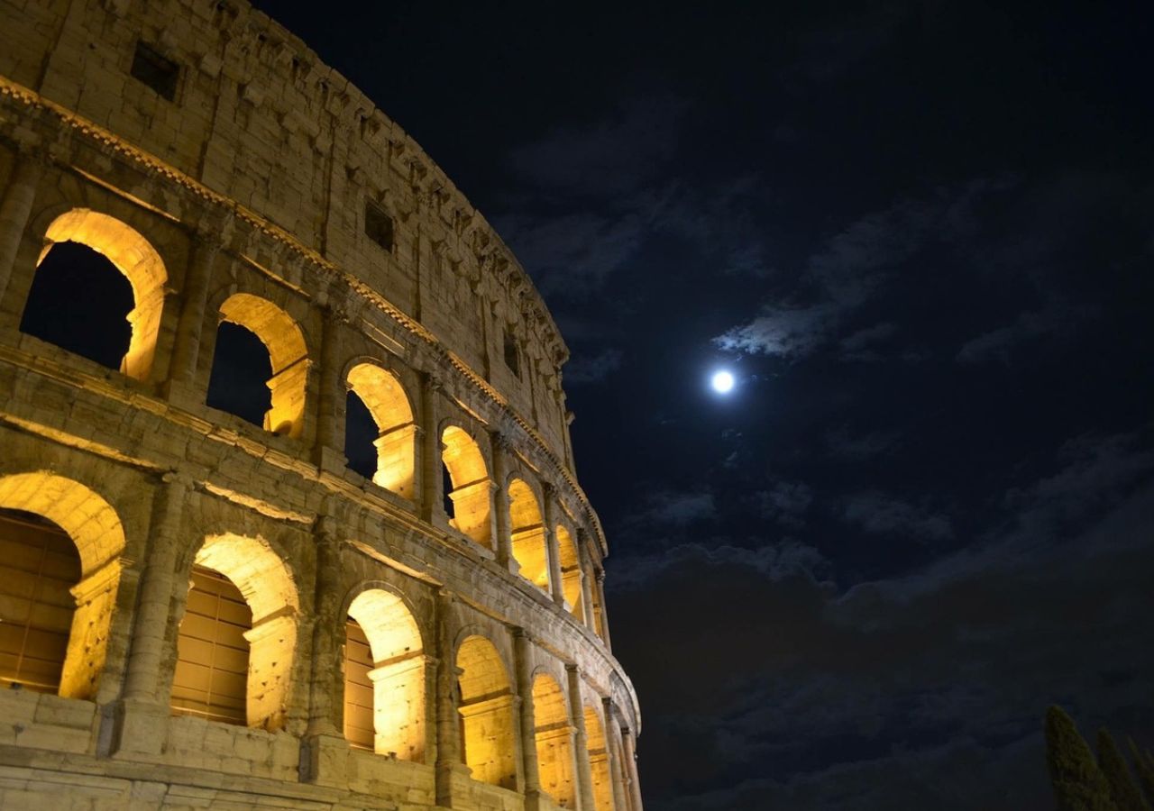 Koloseum nocą z księżycem w tle