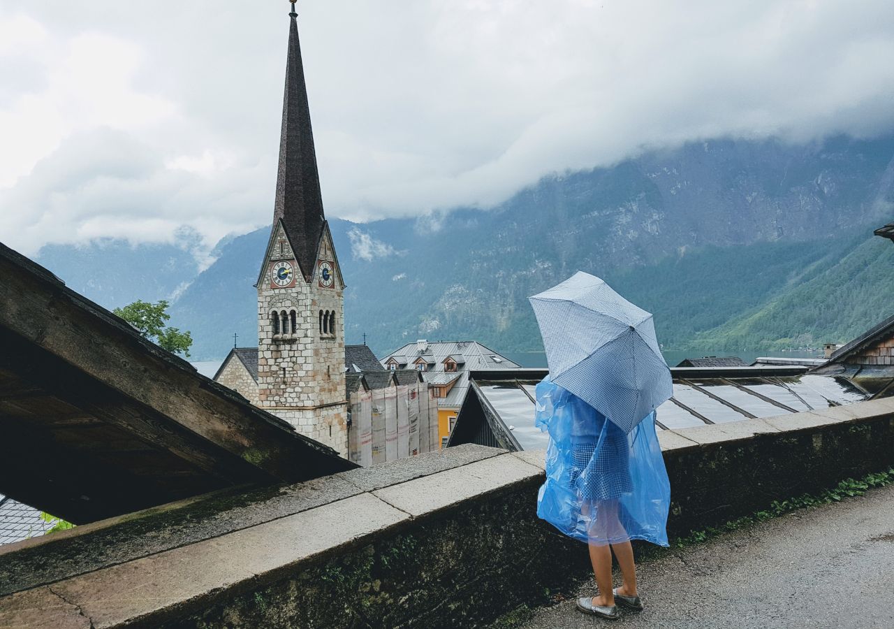 Kościół luterański w Hallstatt - austria i turystka pod porasolem w czasie deszczu