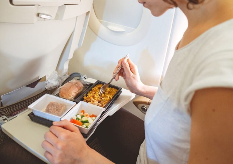 Kobieta w czasie posiłku w samolocie