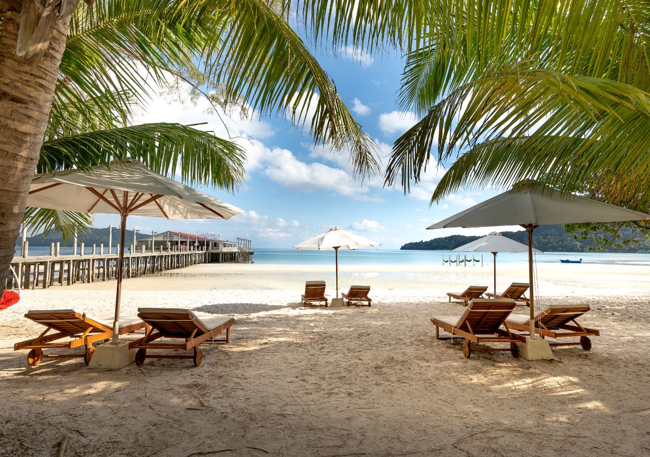 Plaża z palmami i leżaki nad lzaurowym morzem