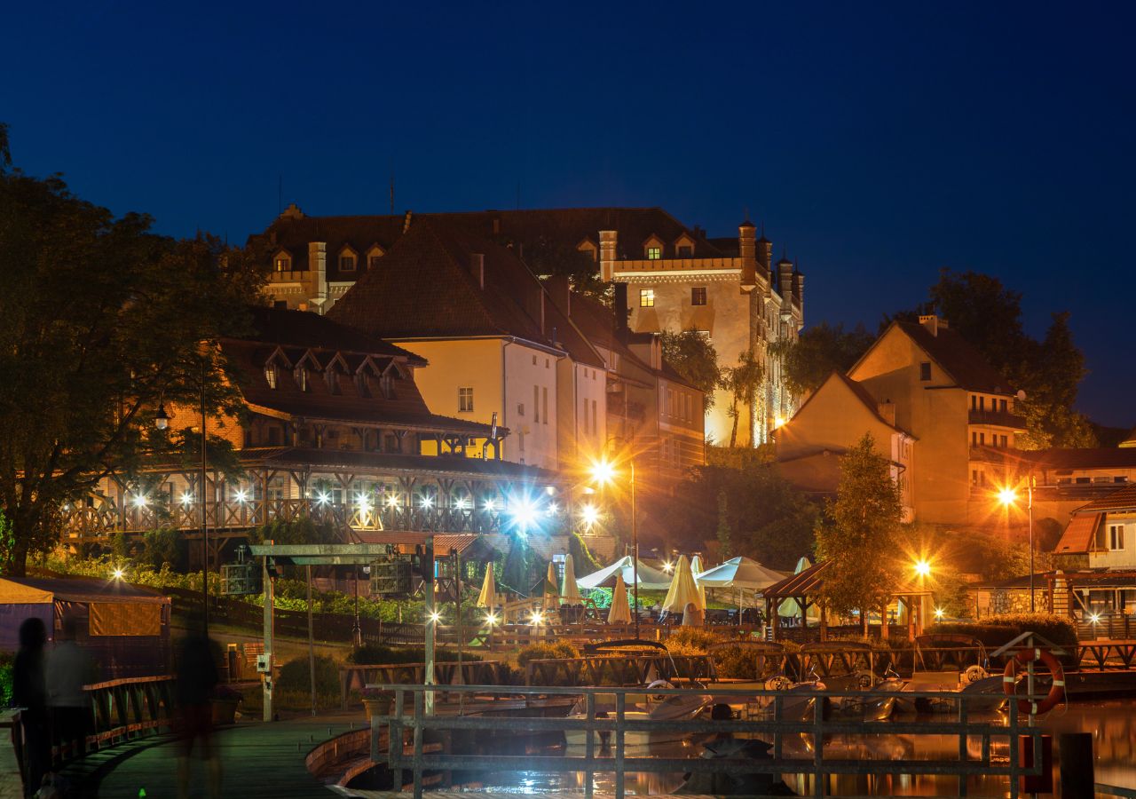 Zamek w Rynie - widok z nadbrzeża nocą, Mazury