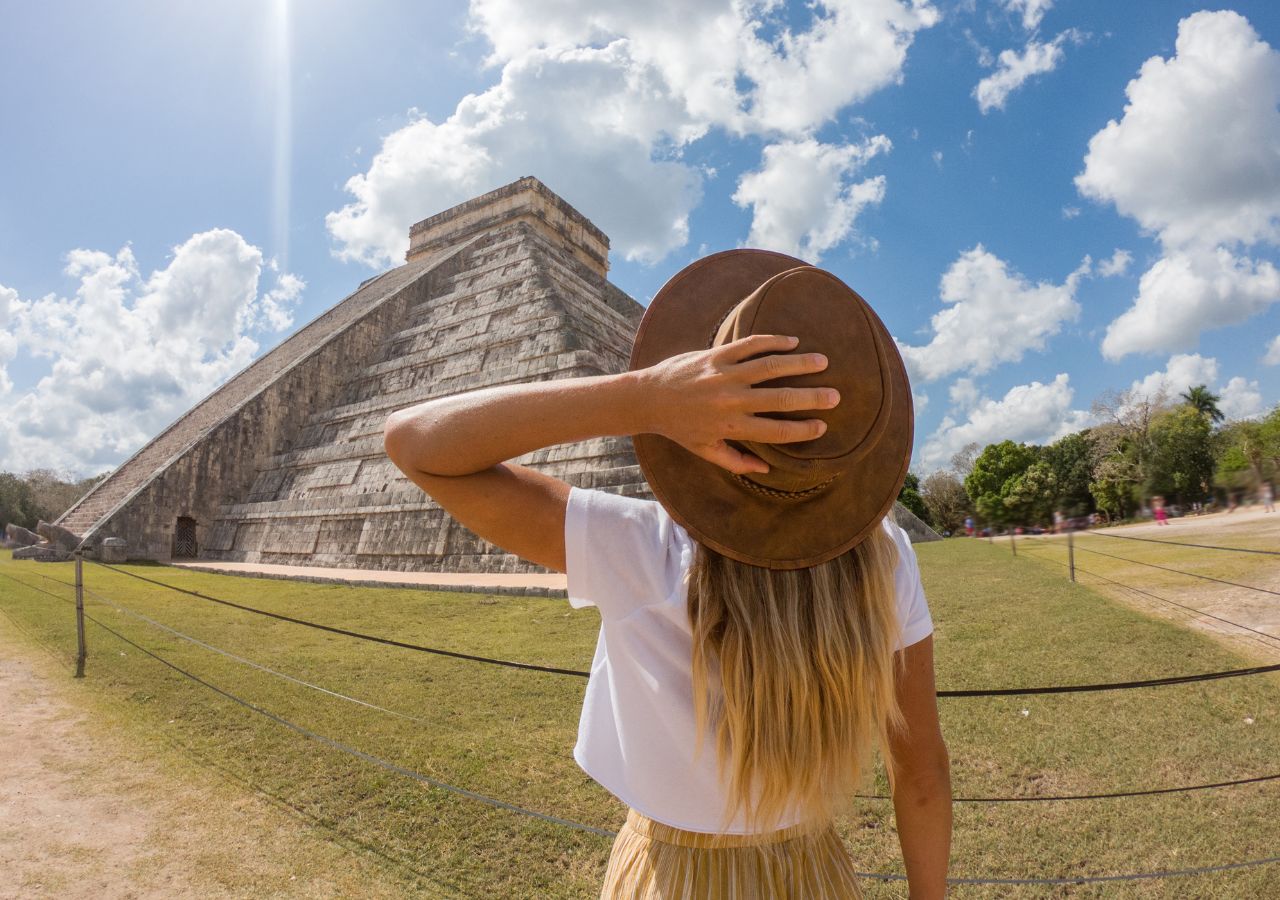 Turystka w kapeluszu przed piramidą Chichen Itza w Meksyku