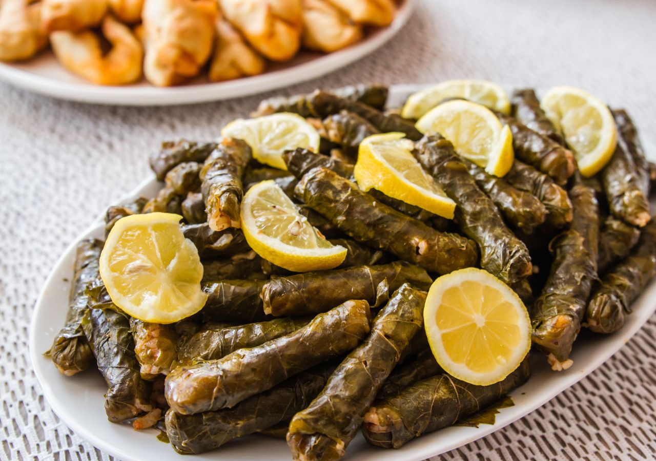 Sarma poprzekłądana cytrynami na białym talerzu - bałkańskie gołąbki