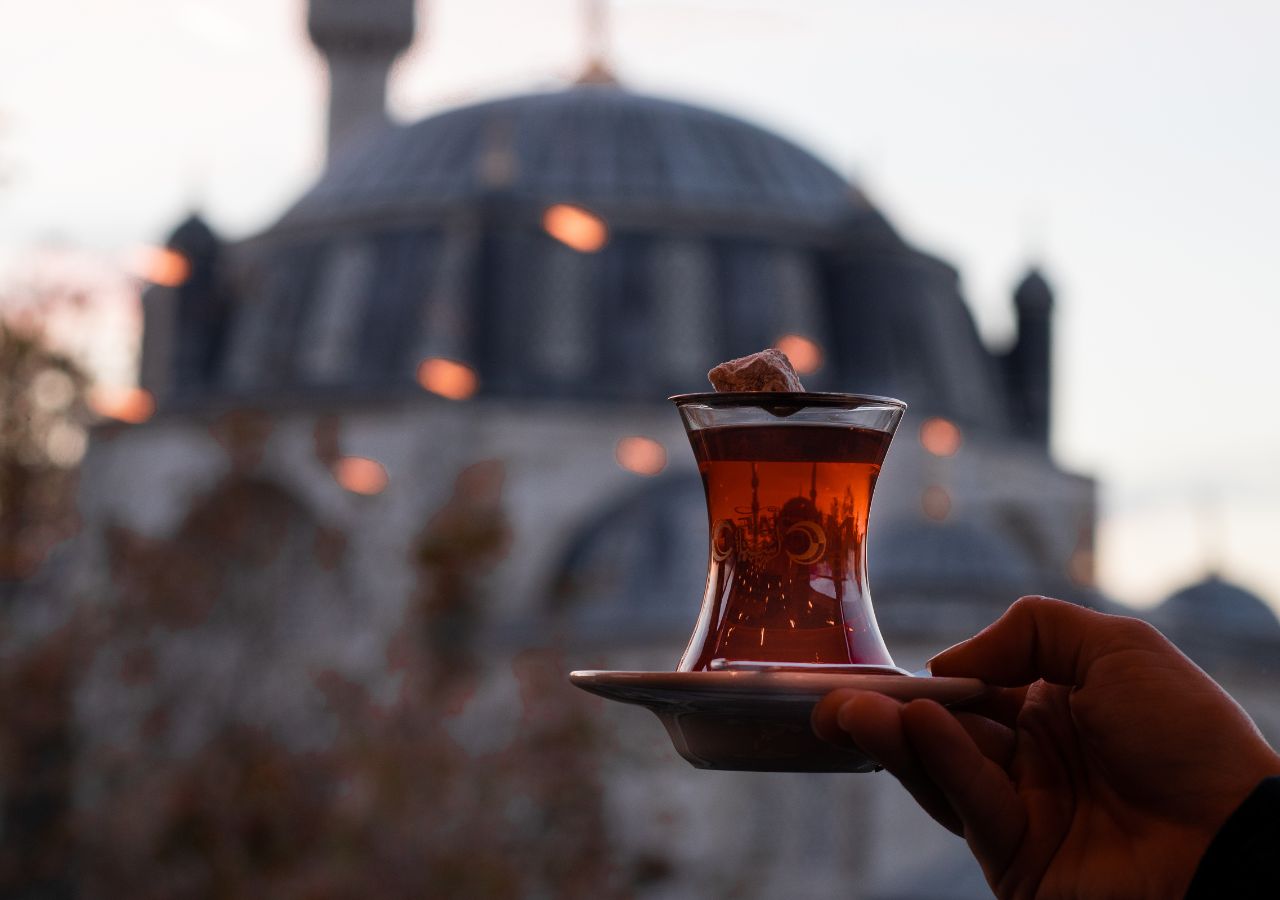 Szklaneczka z turecką herbatą na tle panoramy Stambułu, Turcja