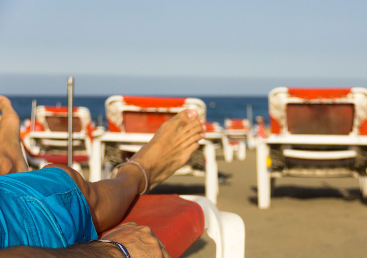 Mężczyzna na hotelowej plaży odpoczywa na leżaku