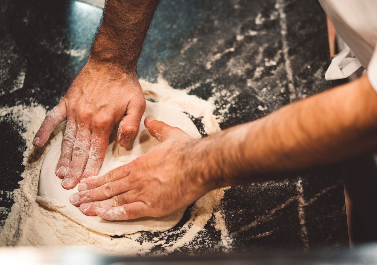 Pizzaiuolo w trakcie wyrabiania ciasta na pizzę neapolitańską