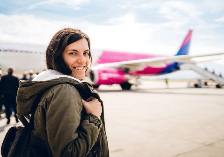 Kobieta z uśmiechem wchodzi na pokład samolotu