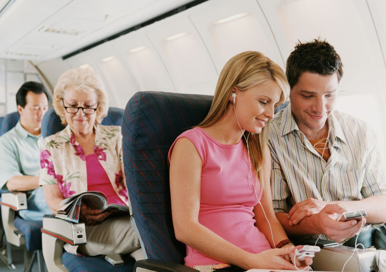 Pasażerowie w odpowiednich ubrania siedzą w samolocie