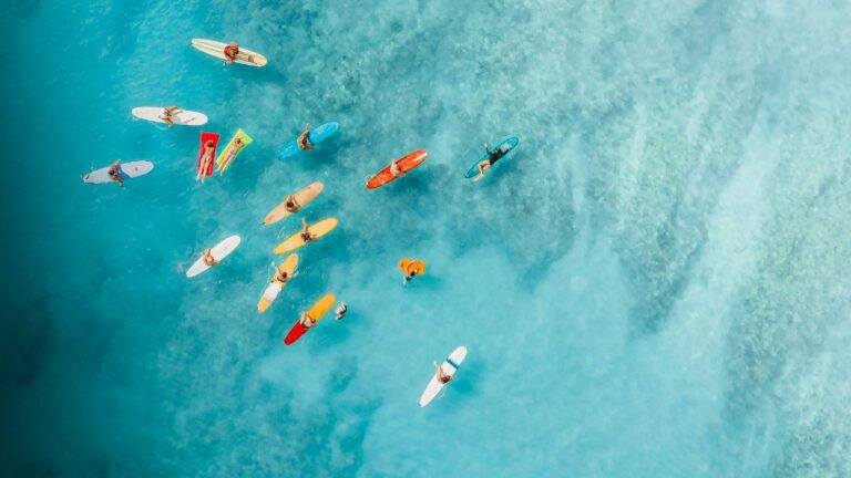 Surferzy na deskach na niebieskim morzu