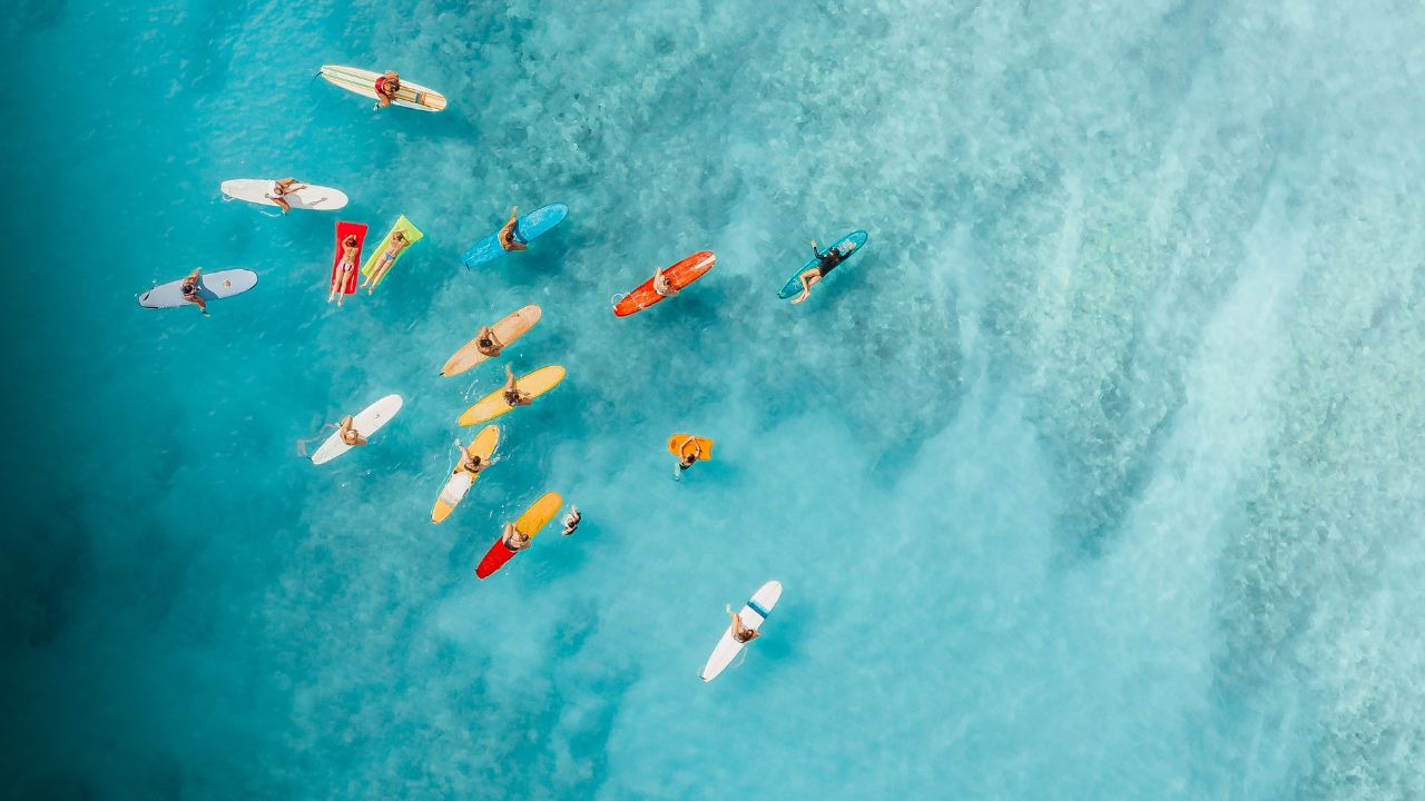 Surferzy na deskach na niebieskim morzu