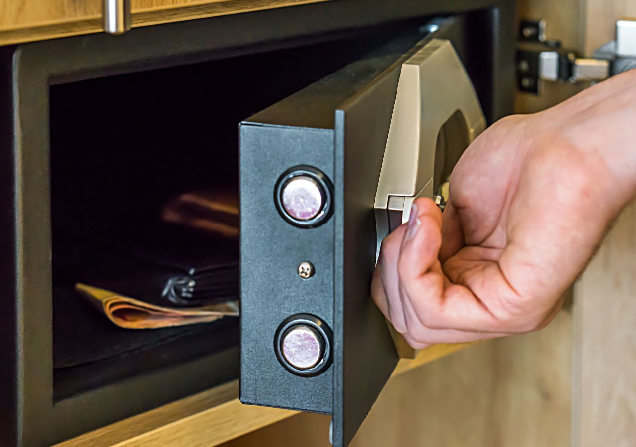 Osoba otwiera sejf hotelowy