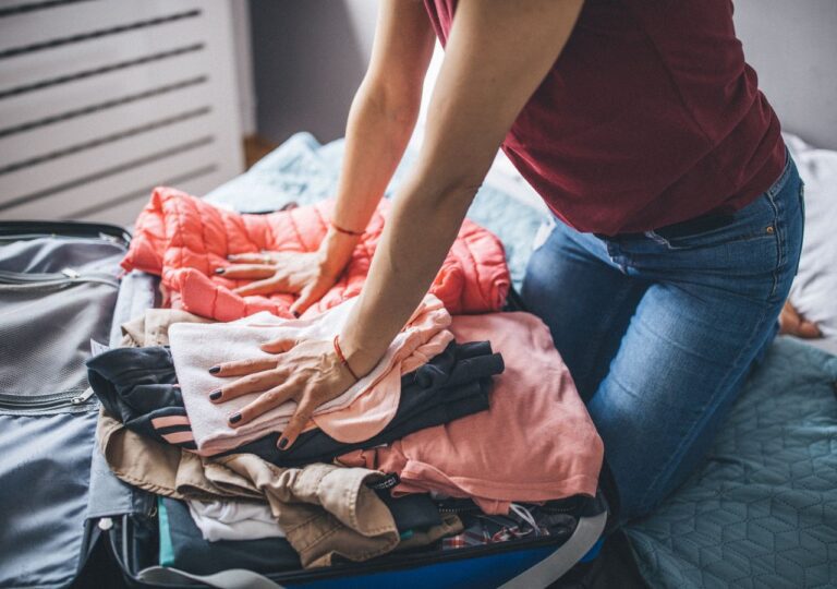 Kobieta w trakcie pakowania walizki