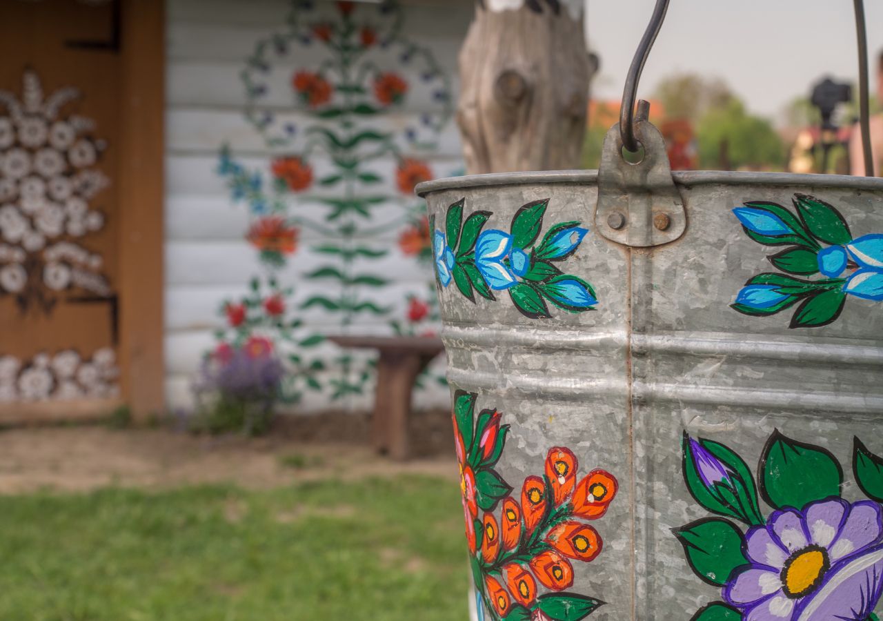 Malowana chata i studnia w małpolskiej wsi Zalipie